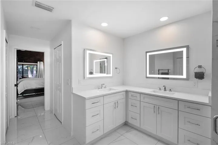 Bathroom with tile patterned floors and dual bowl vanity