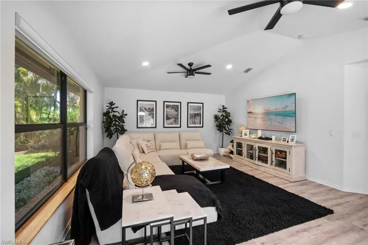 Living room featuring lofted ceiling, light hardwood / wood-style flooring, and ceiling fan