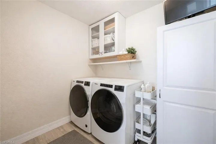 Laundry area featuring washing machine and dryer and light wood-type flooring