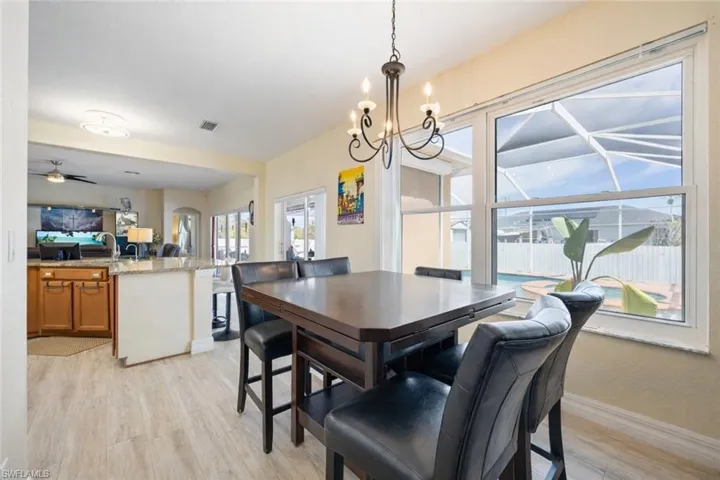 Dining space featuring light wood-style floors, suspended lighting, and ceiling fan