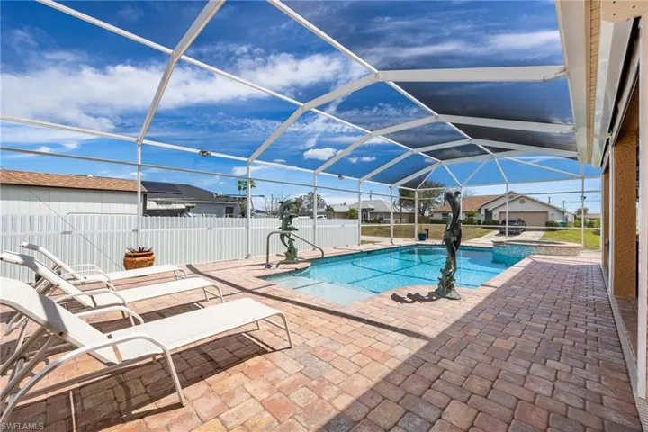 Relaxing pool / spa featuring a sunroom, a lanai, and a patio