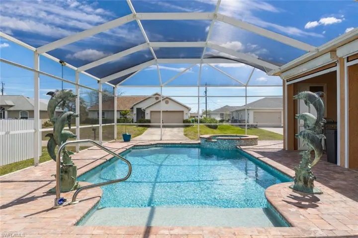 Combined pool / hot tub featuring glass enclosure, a patio area, a sunroom, and a residential view
