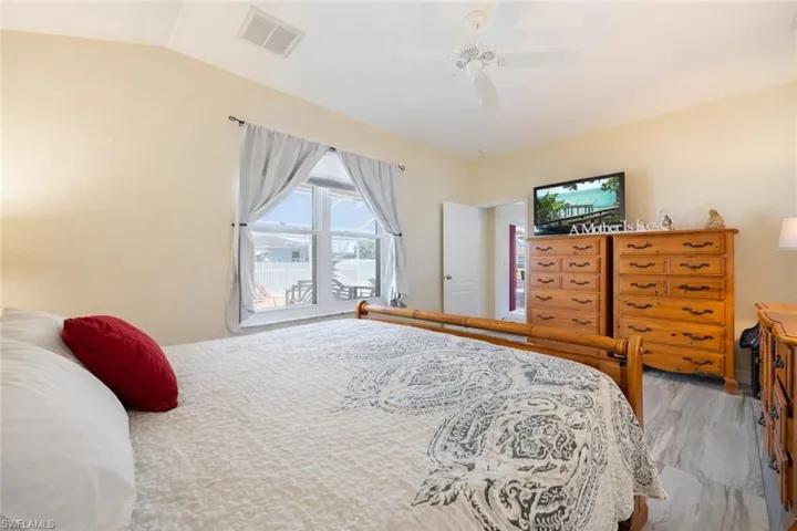 Bedroom featuring ceiling fan, light wood finished floors, and vaulted ceiling