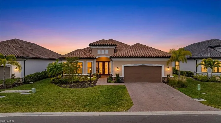 Mediterranean / spanish home with a garage, french doors, a front yard, stucco siding, and a tile roof