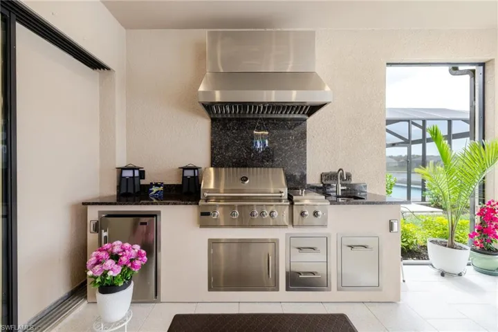View of patio with an outdoor kitchen and a lanai