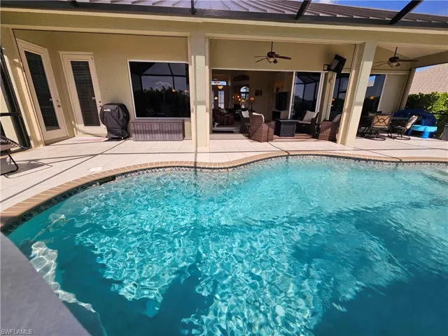 View of swimming pool featuring a patio and ceiling fan