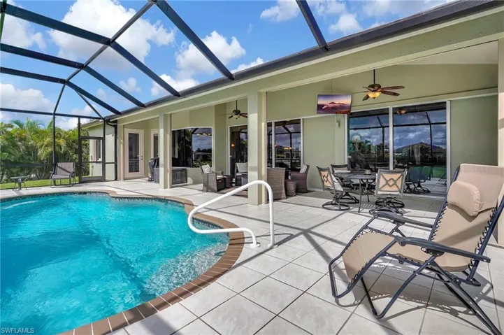 View of pool with ceiling fan, a patio area, and a lanai
