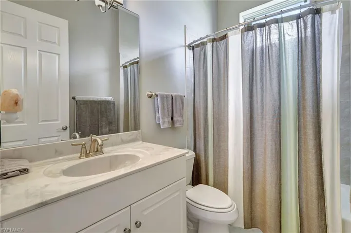Bathroom with vanity, full tub and toilet