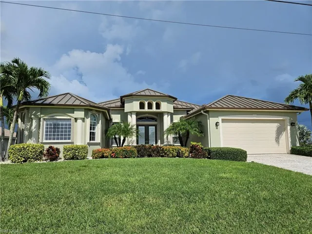 View of front of home with a garage and a front yard