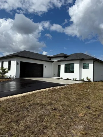View of front of house with a garage and a front lawn
