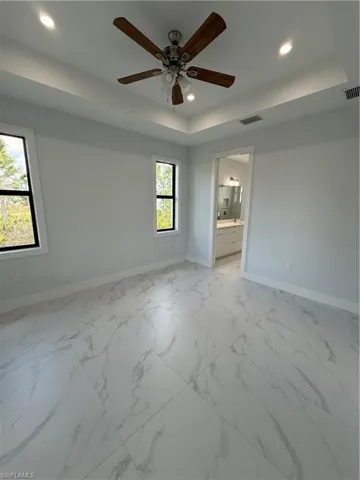 Spare room with a raised ceiling and ceiling fan