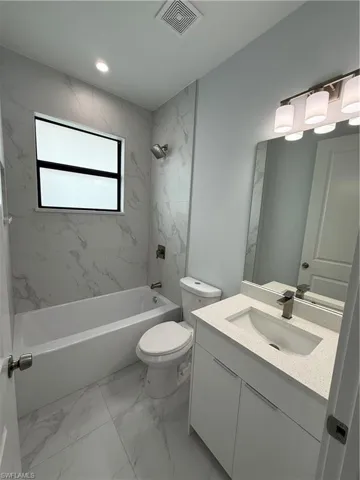 Full bathroom featuring vanity, toilet, and tiled shower / bath