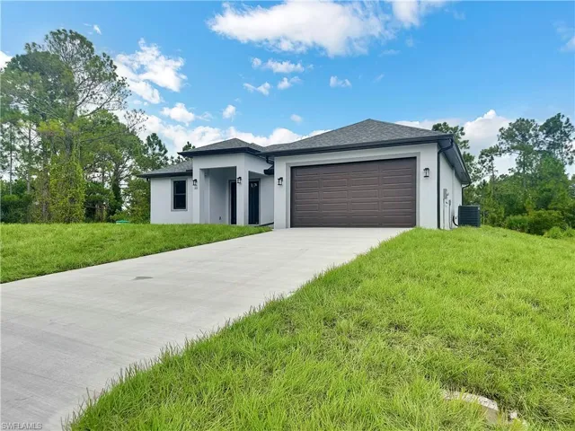 View of front facade featuring a garage and a front yard