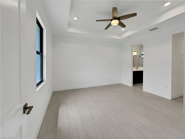 Spare room with ceiling fan and a raised ceiling