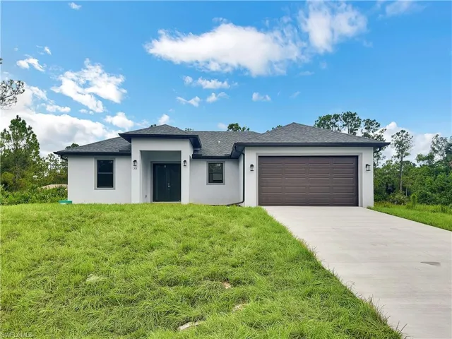 View of front of house with a garage and a front lawn