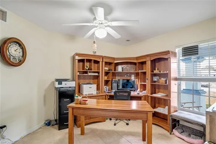 Tiled home office featuring ceiling fan