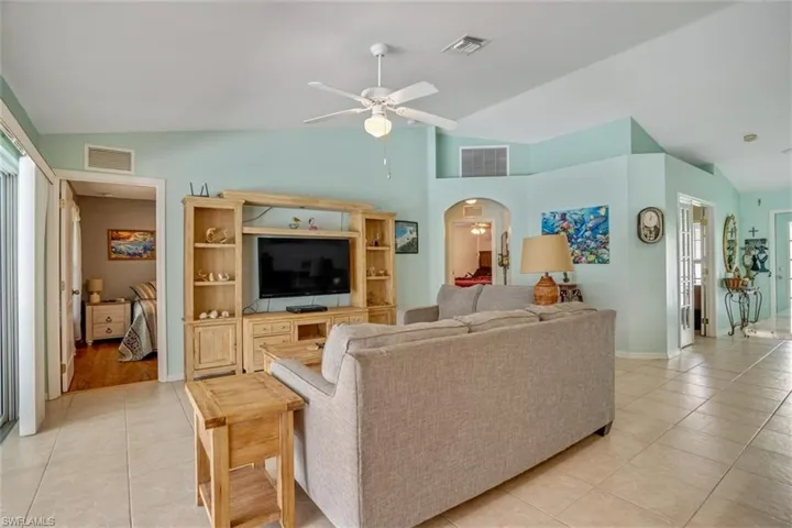 Living room featuring a healthy amount of sunlight, ceiling fan, and lofted ceiling