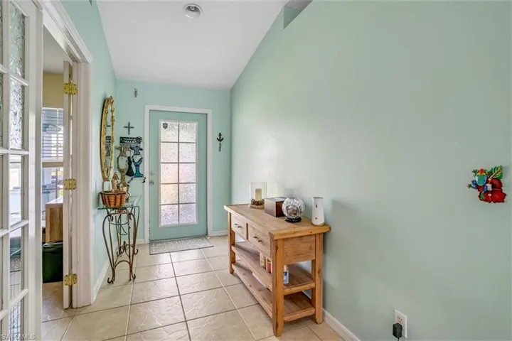 Entryway featuring vaulted ceiling and tile flooring