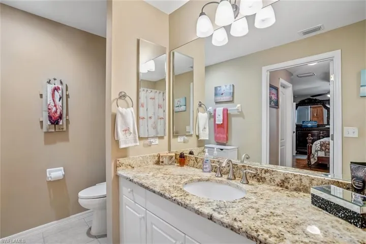 Bathroom featuring tile floors, oversized vanity, and toilet