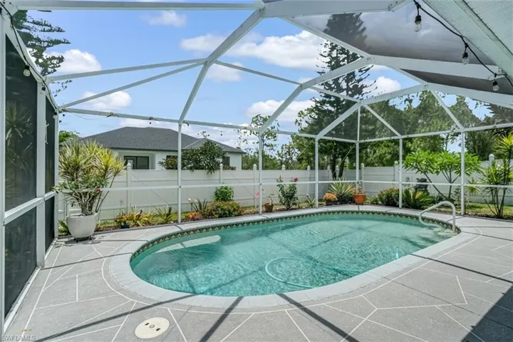 View of pool featuring a patio area and glass enclosure