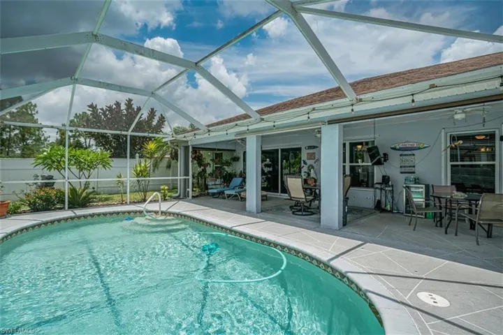 View of pool with a patio and glass enclosure