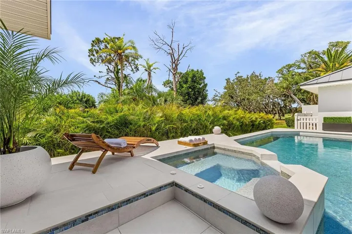 View of swimming pool with a patio area and an in ground hot tub