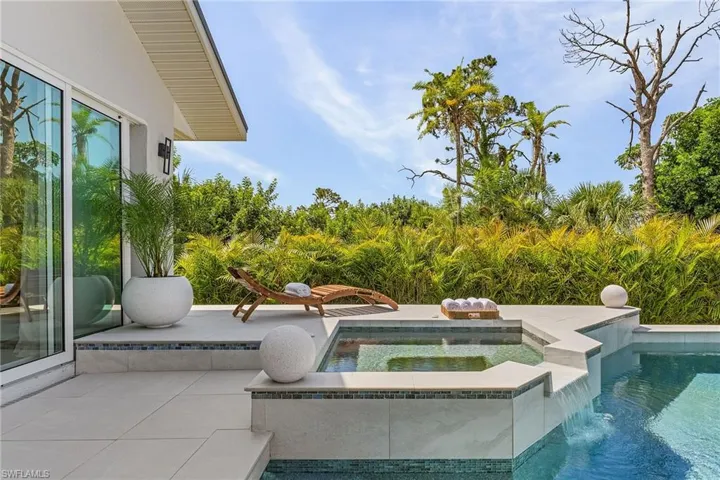 View of pool with a patio and an in ground hot tub