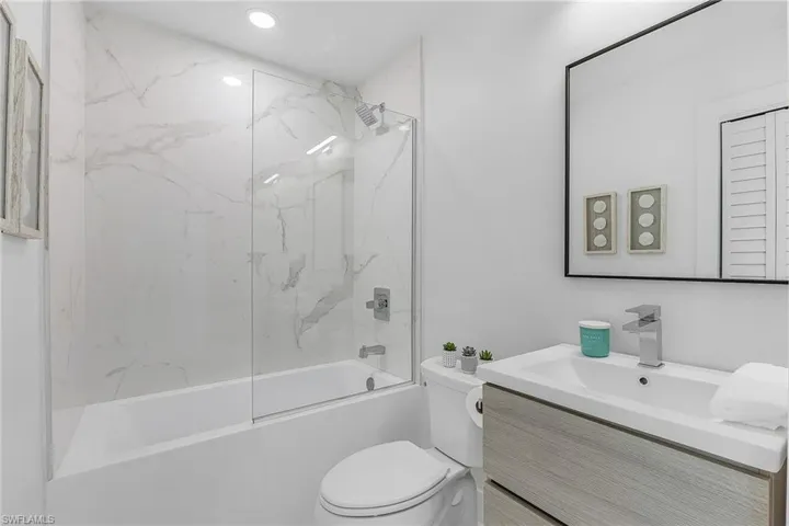 Full bathroom with vanity, toilet, and tiled shower / bath combo