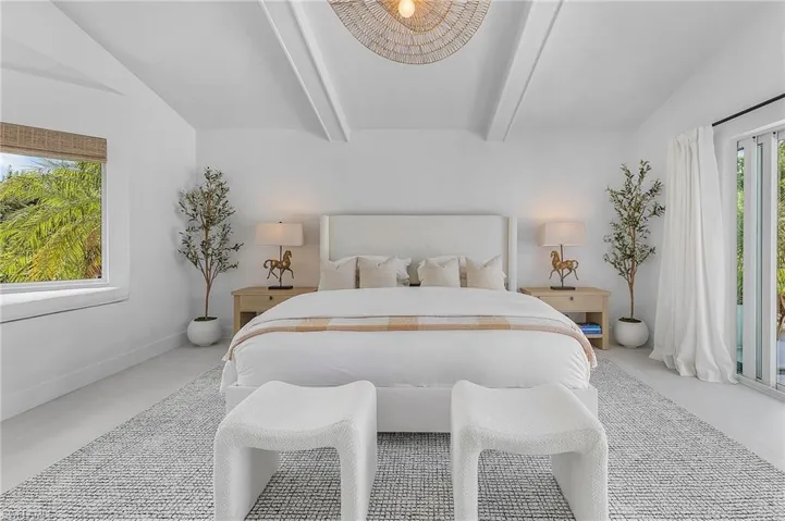 Bedroom featuring tile floors and vaulted ceiling with beams