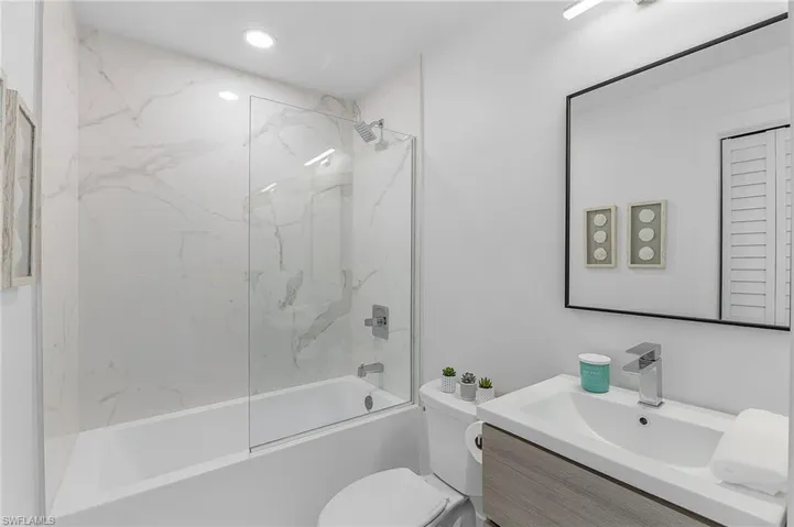 Full bathroom with vanity, toilet, and tiled shower / bath combo