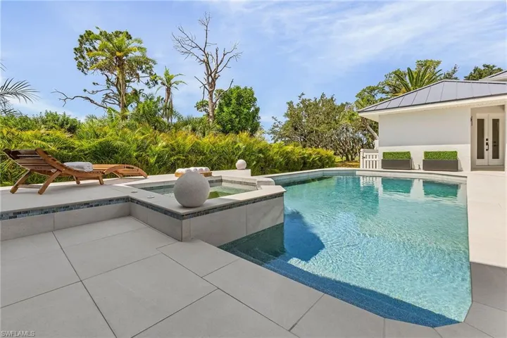 View of swimming pool with a patio, an in ground hot tub, and french doors