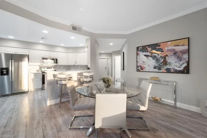 Dining space with crown molding, light wood-style floors, and recessed lighting