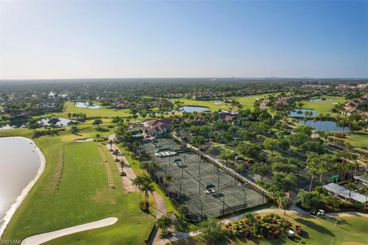 Aerial view of residential area with a local golf course and a nearby body of water
