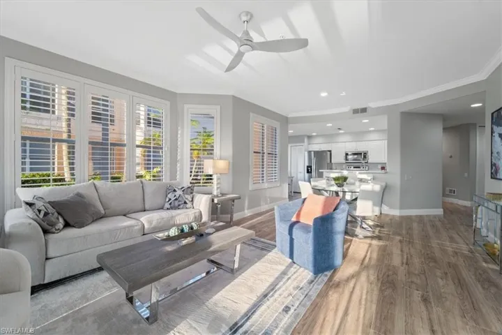 Living area with light wood-type flooring, recessed lighting, a ceiling fan, and ornamental molding