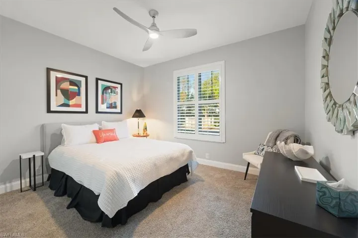 Carpeted bedroom featuring a ceiling fan and baseboards