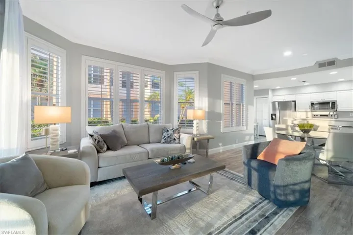 Living room with ornamental molding, wood finished floors, plenty of natural light, a ceiling fan, and recessed lighting