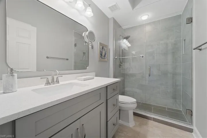 Full bath featuring vanity, a shower stall, and light tile patterned flooring
