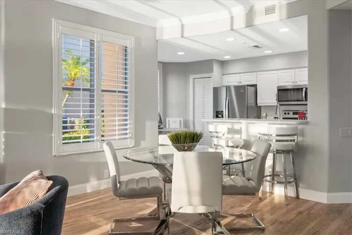 Dining space featuring light wood-type flooring, crown molding, and recessed lighting
