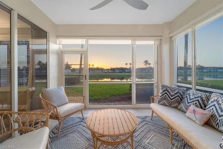 Sunroom with a water view and tile patterned floors