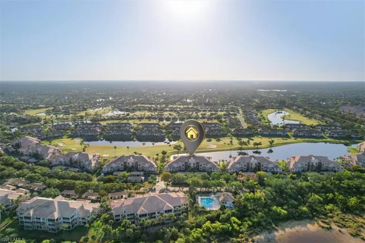 Aerial view of property and surrounding area featuring a large body of water and nearby suburban area