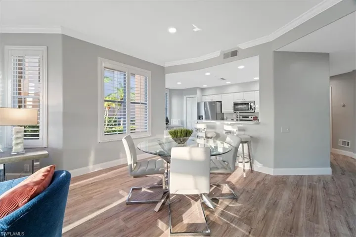 Dining room featuring ornamental molding, light wood-type flooring, and recessed lighting