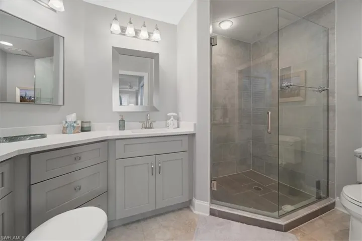 Bathroom with vanity, a stall shower, and light tile patterned floors