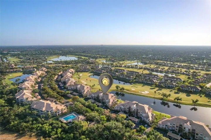 View of property location with a nearby body of water, a golf course, and nearby suburban area