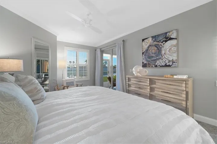 Carpeted bedroom featuring access to exterior, ceiling fan, ornamental molding, and a spacious closet