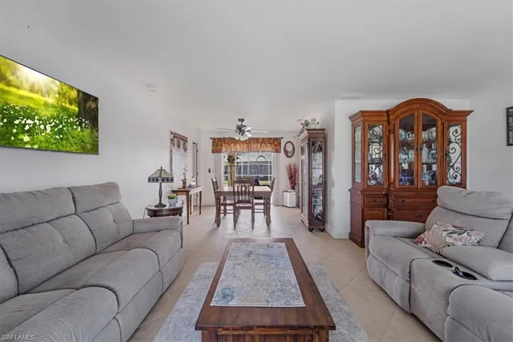Living area featuring light tile patterned floors and ceiling fan