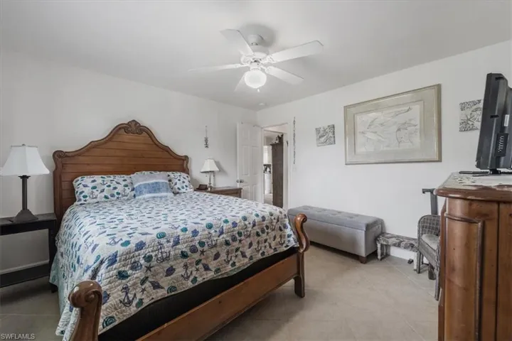 Bedroom with light tile patterned flooring and a ceiling fan