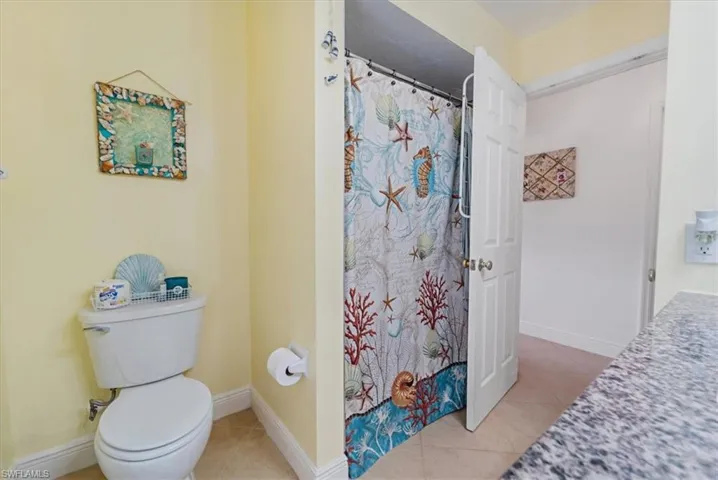 Full bath with tile patterned floors and a shower with curtain