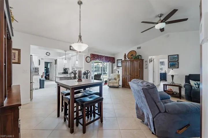 Dining room featuring ceiling fan, lofted ceiling, and light tile patterned flooring