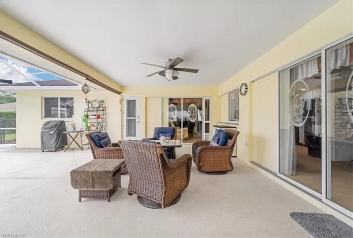 View of patio featuring a ceiling fan, area for grilling, and a lanai