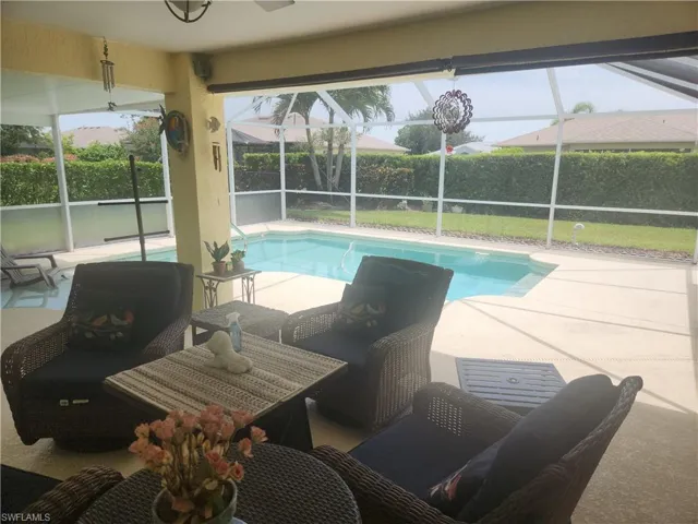 View of swimming pool with a lanai, a patio area, and a lawn
